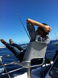 Low angle view of young woman on boat against clear sky