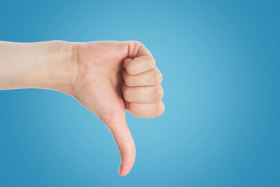 Close-up of hand against blue background