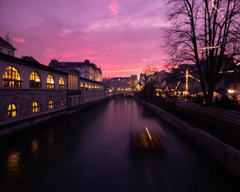 Illuminated bridge over river against sky at night