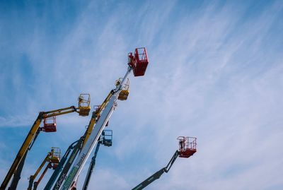 Low angle view of cranes against sky