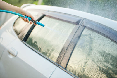 Cropped hand of person washing car