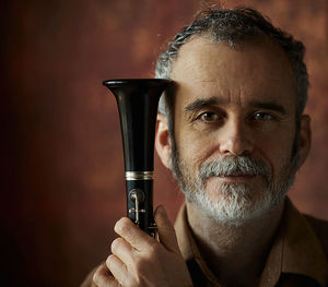 Portrait of a musician whose hands hold the clarinet - an ancient musical wooden popular instrument