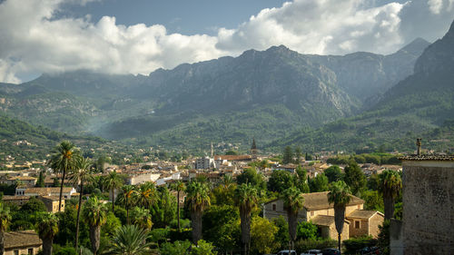 Scenic view of townscape and mountains against sky