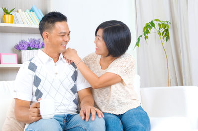 Young woman with daughter sitting on sofa at home