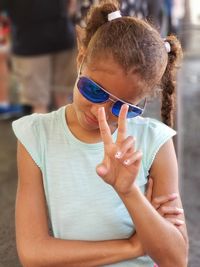 Smiling girl gesturing while wearing sunglasses