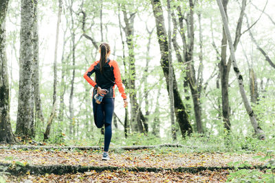 Rear view of woman standing in forest