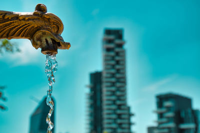 Low angle view of statue against buildings in city