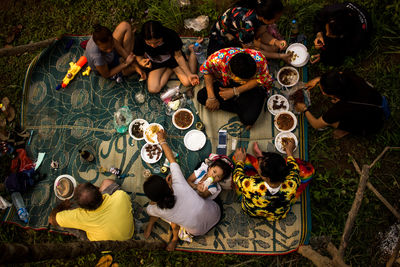 High angle view of people sitting on field