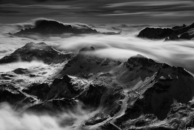 Scenic view of clouds covering snowcapped mountains