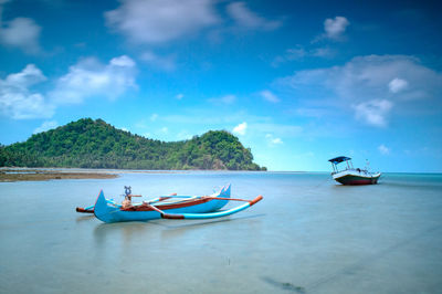 Boats moored on sea against sky