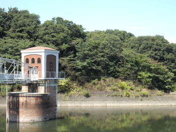 Built structure by lake against sky