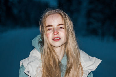 Portrait of young woman against blue background