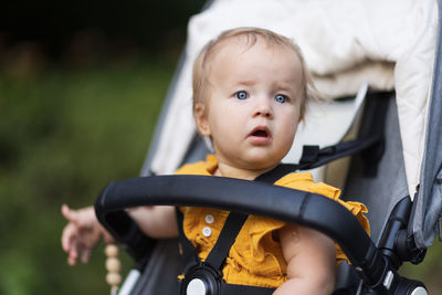 Portrait of cute baby boy sitting in park