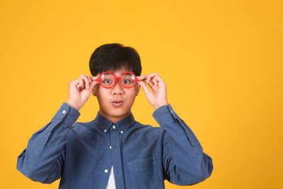 Portrait of boy against yellow background