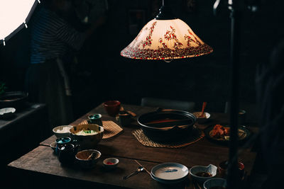 Illuminated lighting equipment over table in restaurant