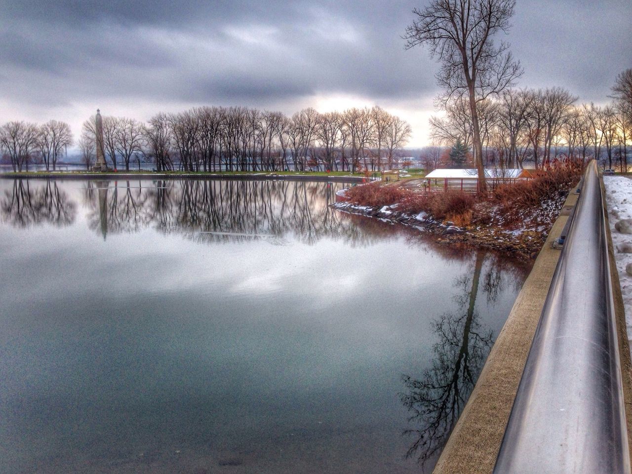 sky, cloud - sky, tree, transportation, reflection, water, cloudy, weather, bare tree, lake, river, nature, cloud, tranquility, mode of transport, tranquil scene, scenics, beauty in nature, winter, season