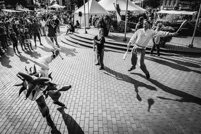 High angle view of people performing on footpath in city