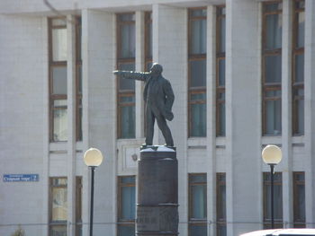 Statue against building in city
