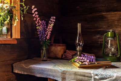 Still life of vintage items and a bouquet of lupins on a table by the window in an  village house