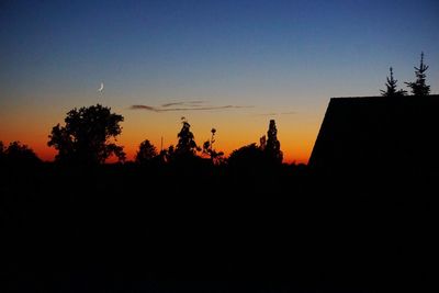 Silhouette trees against clear sky during sunset