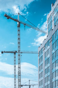 Low angle view of crane against sky