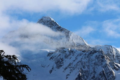 Low angle view of snowcapped mountains against sky