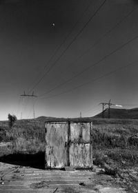 Electricity pylon on field against clear sky