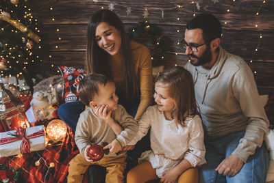 Cheerful family sitting on bed at home