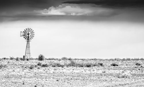 Traditional windmill on field against sky