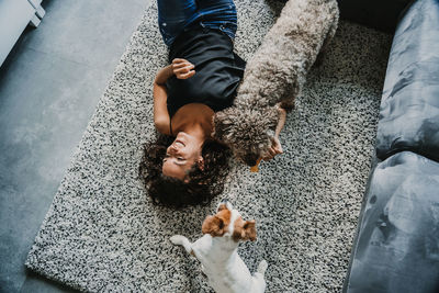High angle view of woman and dogs on floor