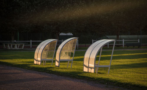 Empty benches on field in park at night
