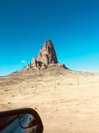 Scenic view of arid landscape against clear blue sky