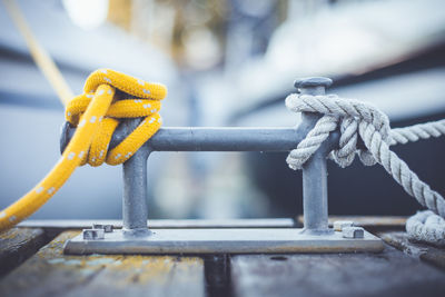 Close-up of rope tied on metal against sky