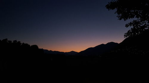 Silhouette mountains against clear sky at sunset