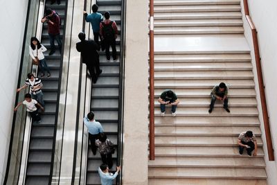 High angle view of people on steps and escalator in building