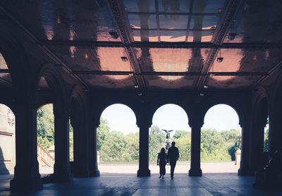 Rear view of two people standing in old building