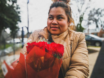 Close-up of woman with bouquet in city