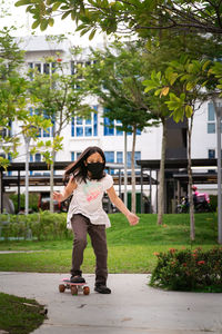 Full length of girl playing with skateboard outdoors