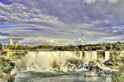 Scenic view of waterfall against sky