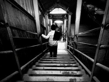 Rear view of man standing on staircase