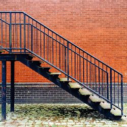 Metal staircase against brick wall