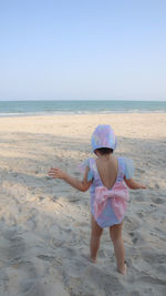 Boy on beach against clear sky