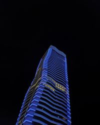Low angle view of illuminated building against sky at night