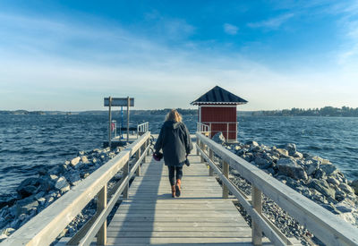 Rear view of woman standing on pier