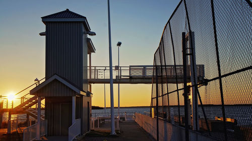 Bridge over sea against clear sky during sunset