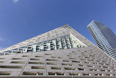 Low angle view of modern buildings against blue sky