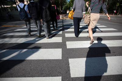 Low section of people walking on crosswalk