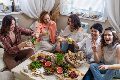 Group of people sitting on table at home