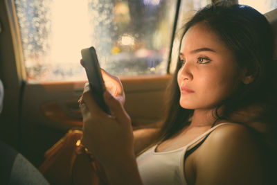 Portrait of young woman using mobile phone