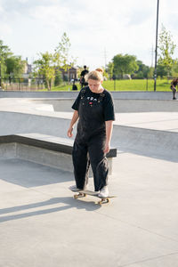 Full length of young man standing on skateboard